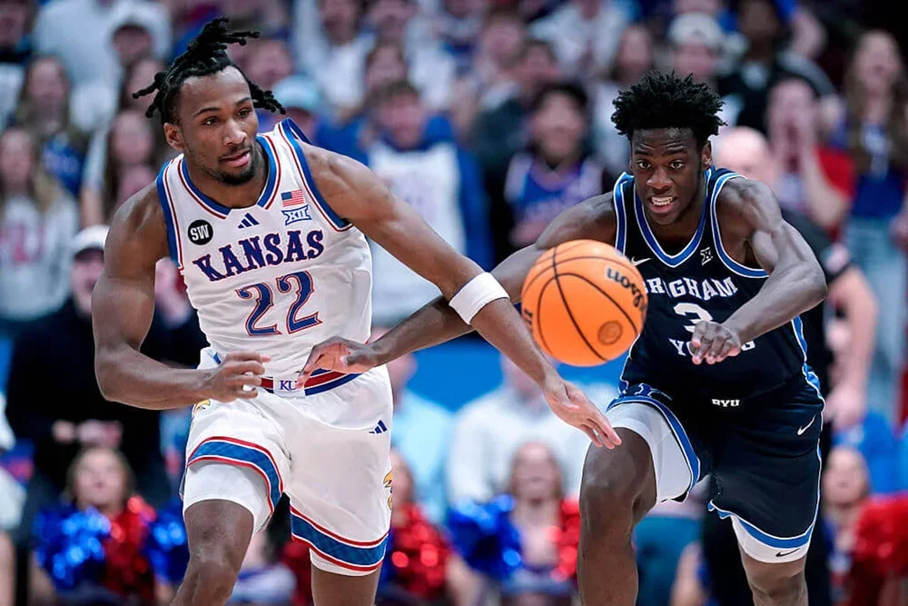Kansas' Darryn Peterson and BYU's AJ Dybantsa reach for a loose ball.